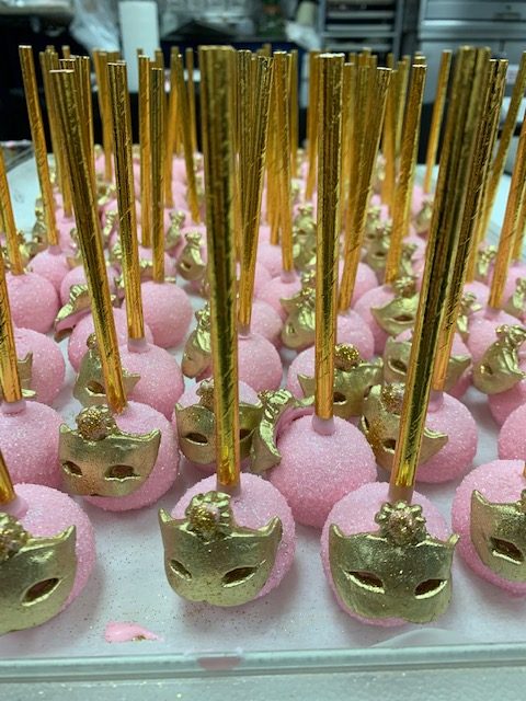Pink Cake Pops with gold Masks on them